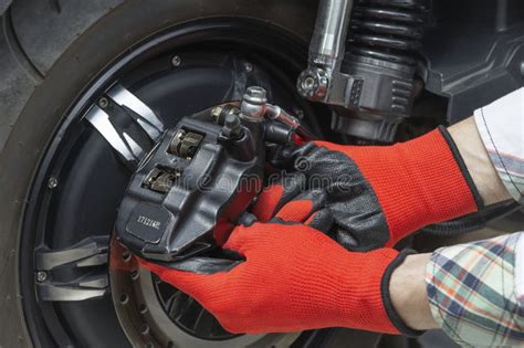 The Master Removes The Brake Caliper Of An Electric Motorcycle Stock
