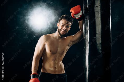 Foto De Smiling Handsome Man Boxer In Red Gloves Leans Against A Punching Bag Naked Man S Torso