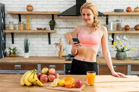 Femme Blonde Dans La Cuisine Avec Des Fruits Photo Gratuite