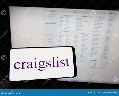 Person Holding Mobile Phone with Logo of Classified Advertisements