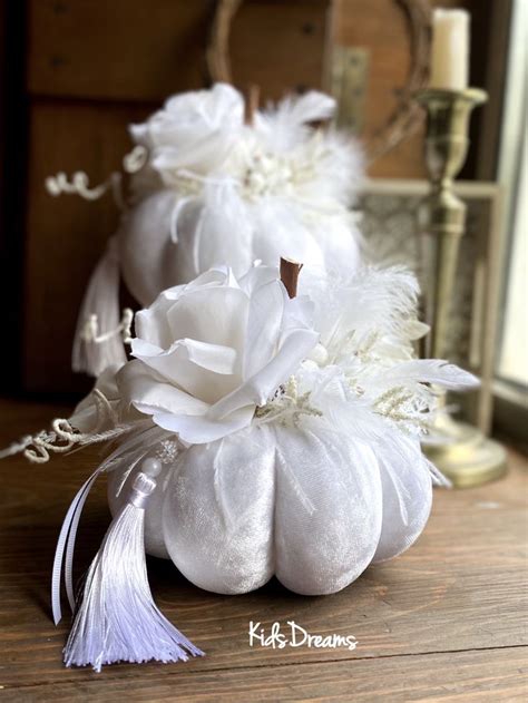 A White Pumpkin Decorated With Flowers And Feathers