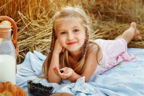 A Cute Blonde Is Lying On A Blanket In A Wheat Field Picnic In Nature With Milk Bread Berries