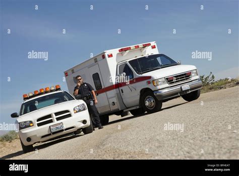 Police Officer Standing By Police Car And Ambulance Stock Photo Alamy