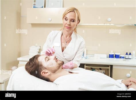 Mature Woman Smearing Face Cream On Male Cheek Stock Photo Alamy
