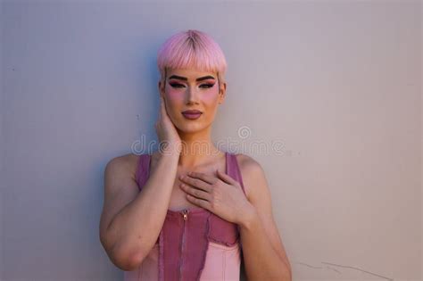 Retrato De Un Joven Gay Con Pelo Rosado Y Maquillaje Parado En Un Fondo Blanco Y Haciendo