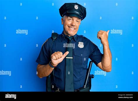 Handsome Middle Age Mature Man Wearing Police Uniform Pointing To The Back Behind With Hand And