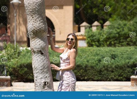 Jovem E Bonita Loira E Latina Se Deita No Tronco De Uma Palmeira No Parque Fazendo Diferentes