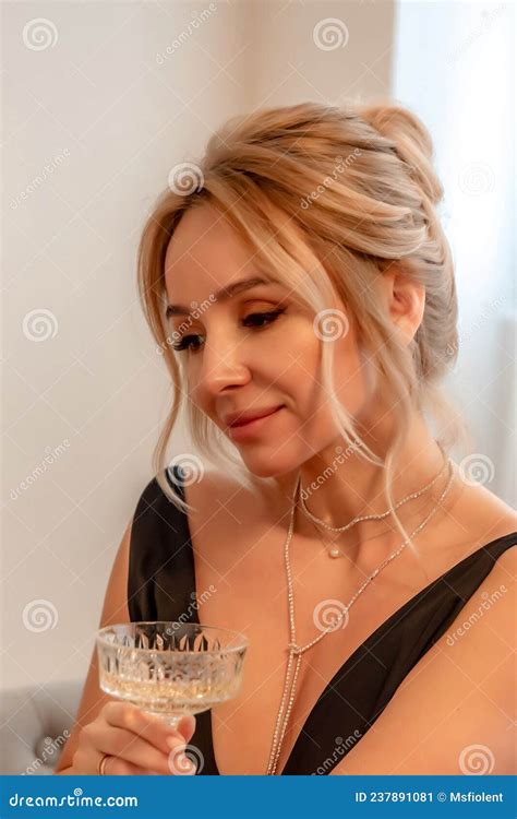 Portrait Of A Wealthy Mature Woman With Evening Makeup And Hairstyle Posing In A Black Dress