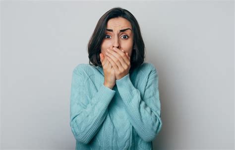 Premium Photo Young Shocked Woman Closed Her Mouth With Crossed Hands