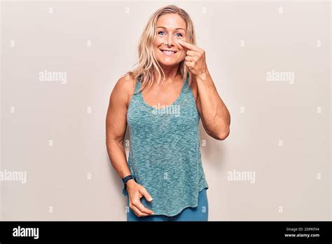 Mittelalter kaukasische blonde Frau trägt Sportkleidung zeigt mit der