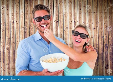 Composite Image Of Happy Young Couple Wearing 3d Glasses Eating Popcorn