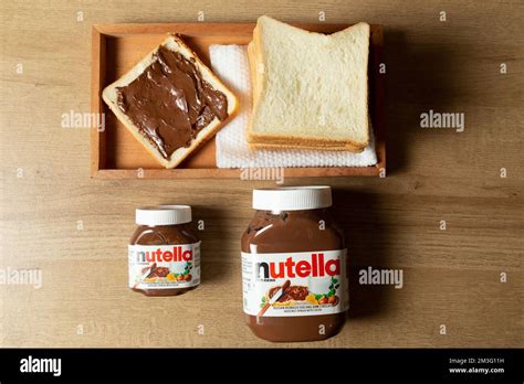 Nutella With Large And Small Bottles And Some White Bread Neatly