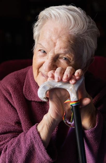Anciana con cinta de arco iris gay en su bastón concepto homosexualidad y anciana lesbiana