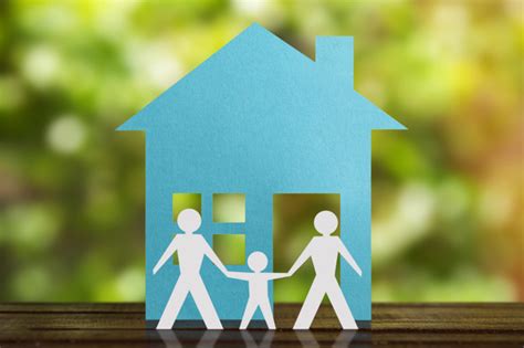 Figura de papel de um casal gay de mãos dadas o filho adotivo casa azul e fundo desfocado