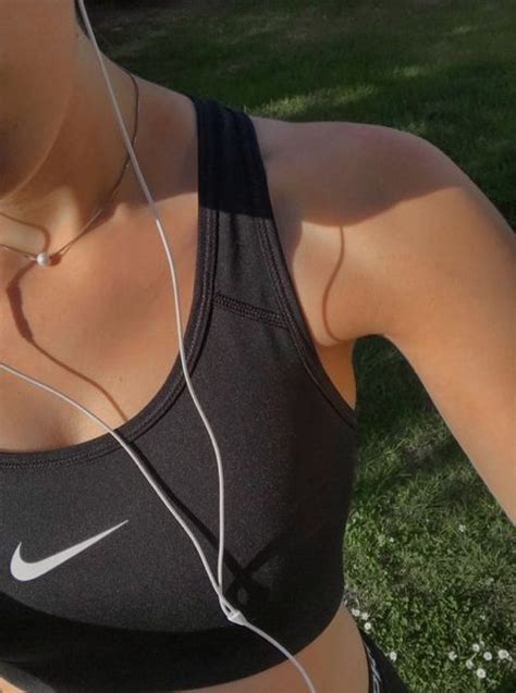 A Woman Wearing Headphones While Standing In The Grass