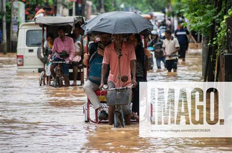 October Commuters On A Rickshaw To Cross A Waterlogged Road