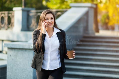 Mulher De Neg Cios Que Fala No Telefone Ao Andar Exterior Imagem De