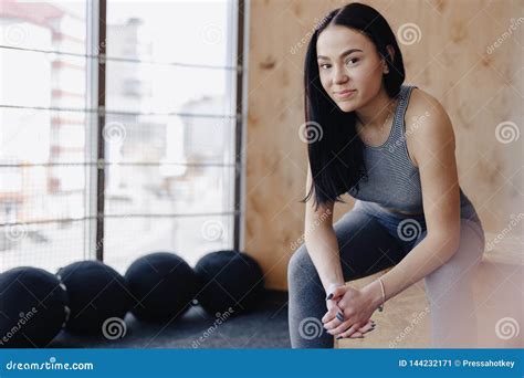 Young Girl in Sportswear in a Gym in a Simple Background, a Theme of