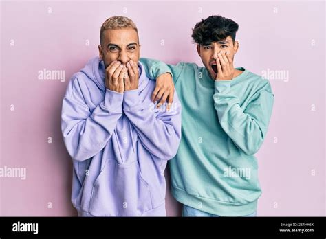 Homosexual Gay Couple Standing Together Wearing Casual Clothes Laughing And Embarrassed Giggle