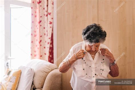 elderly curly gray haired female  white shirt standing close