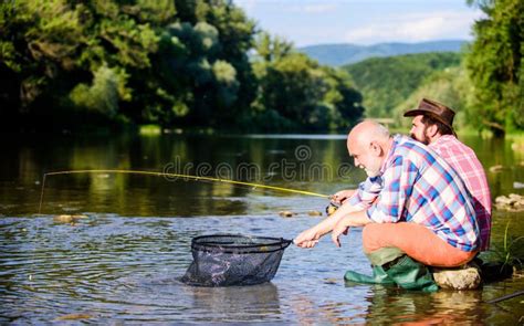 Retired Father And Mature Bearded Son Two Male Friends Fishing Together Fly Fish Hobby Of Men