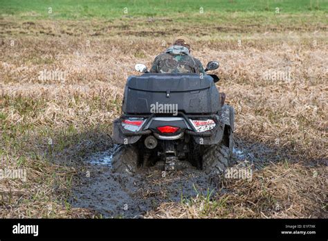 Young man badly stuck in mud with his quadbike Stock Photo - Alamy
