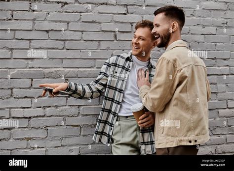 Smiling Gay Couple Standing In Front Of Brick Wall Stock Photo Alamy