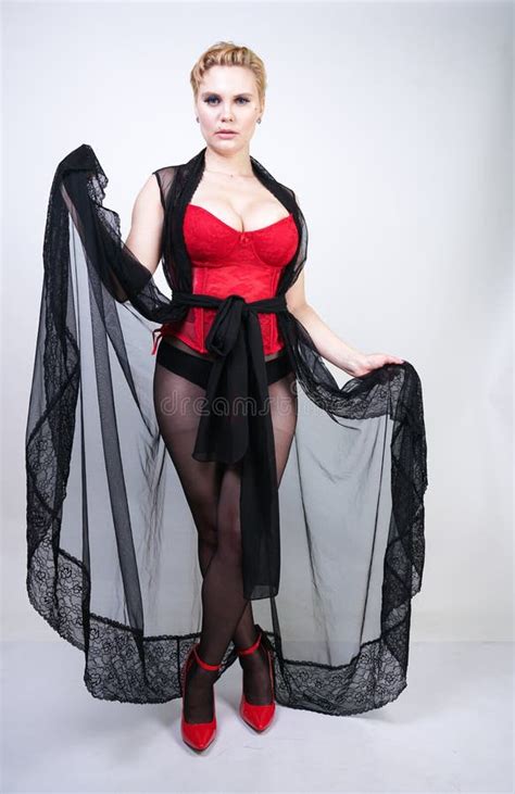 Beautiful Chic Plus Size Blonde With Short Hair In Red Lace Corset And Black Sheer Long Robe In