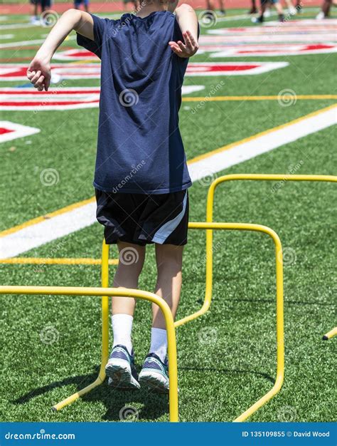 Youth Athlete Jumping Over Two Foot Yellow Hurdles Stock Image - Image