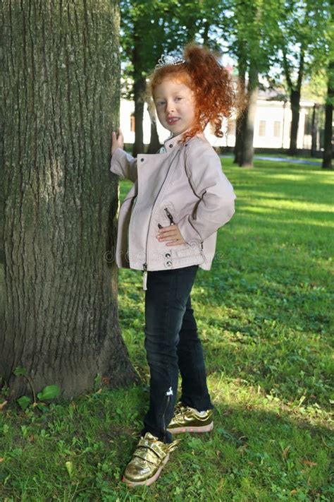 Счастливая маленькая девочка с красными волосами в кожаной куртке ...