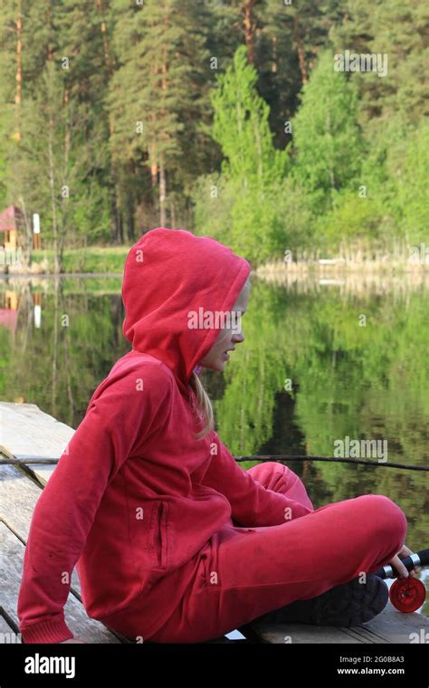 Une Adolescente Blonde En Costume Rouge Est Assise Sur Un Pont En Bois Au Bord D Un Lac