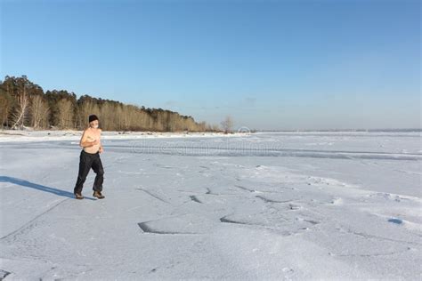 Man In A Cap With A Naked Torso Running Across The Ice Of A Frozen River Stock Photo Image Of