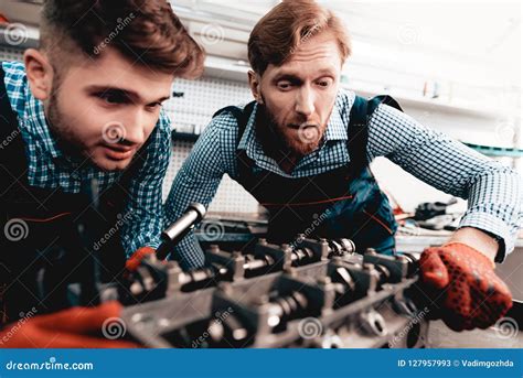 Meccanici Vicini A Me - Due Meccanici Stanno Controllando Il Dettaglio in Garage Immagine Stock ...