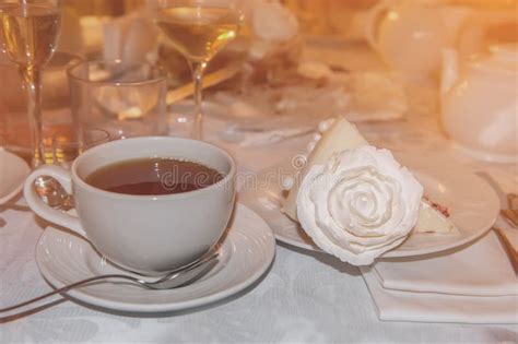 Hot Tea In Glass Transparent Cup And A Piece Of Cake Decorated With A Rose At The Restaurant