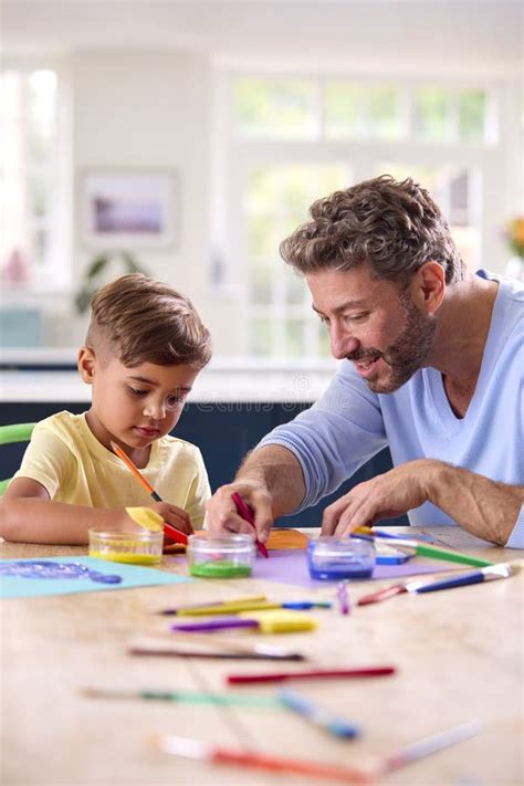 Mature Father At Home In Kitchen With Son Painting Picture Together Stock Photo Image Of