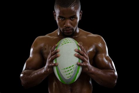 Portrait Of Shirtless Male Athlete Holding Rugby Ball Stock Photo