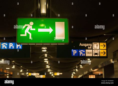 Illuminated emergency exit sign at airport Stock Photo - Alamy