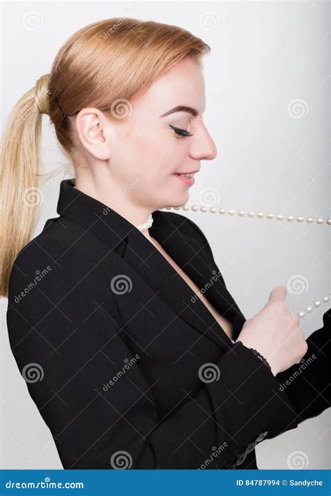 Attractive And Energetic Business Woma In A Suit On Naked Body Smiling Holding Pearls Stock