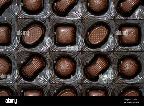 Assorted chocolates in a box top view. Sweets of different shapes made ...