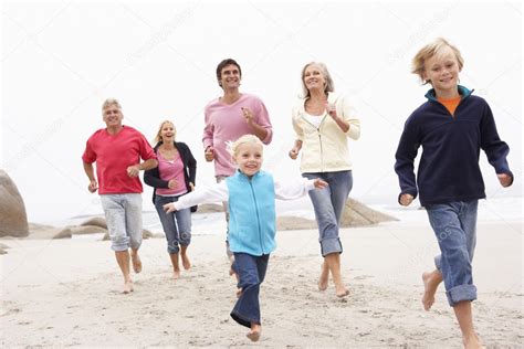 Famille Trois Générations Courant Long Plage D hiver Ensemble image