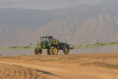 Tractor Trailer With Boom Arms Watering The Ground Before Sowing Seeds