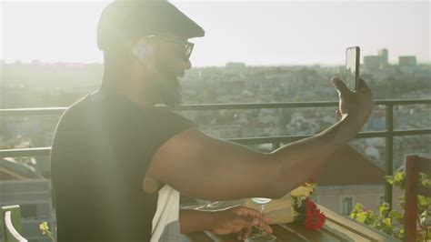 Vídeo Gratis Emocionado hombre gay negro mostrando flores a su amante a través de una videollamada