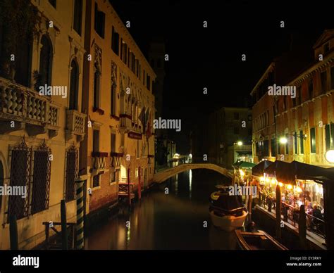 View of a canal in the city of Venice with a canalside restaurant at ...