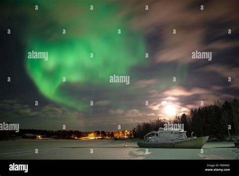 Boat In Frozen Lake Under Full Moon And Aurora Borealis Stock Photo Alamy