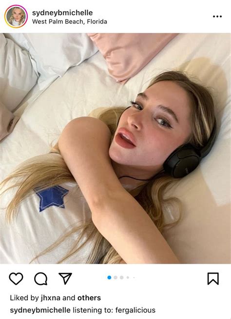 A Woman Laying In Bed With Headphones On