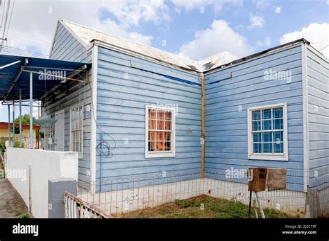 House With Light Blue Wooden Facade And White Framing In The Suburbs Of