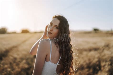 Spanish Blonde Looking Over Her Shoulder At The Camera With The Sun Shining Behind Her In A