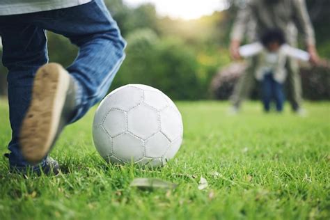 Pernas De Crian A E Chutar Bola De Futebol Na Grama Para Divers O Na