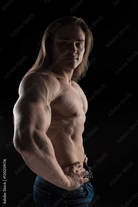 Naked Torso Male Bodybuilder Athlete With Long Blond Hair In Studio On A Black Background Stock
