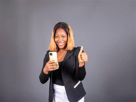 Une Femme Africaine Excit E Tenant Son T L Phone Portable L Aide D